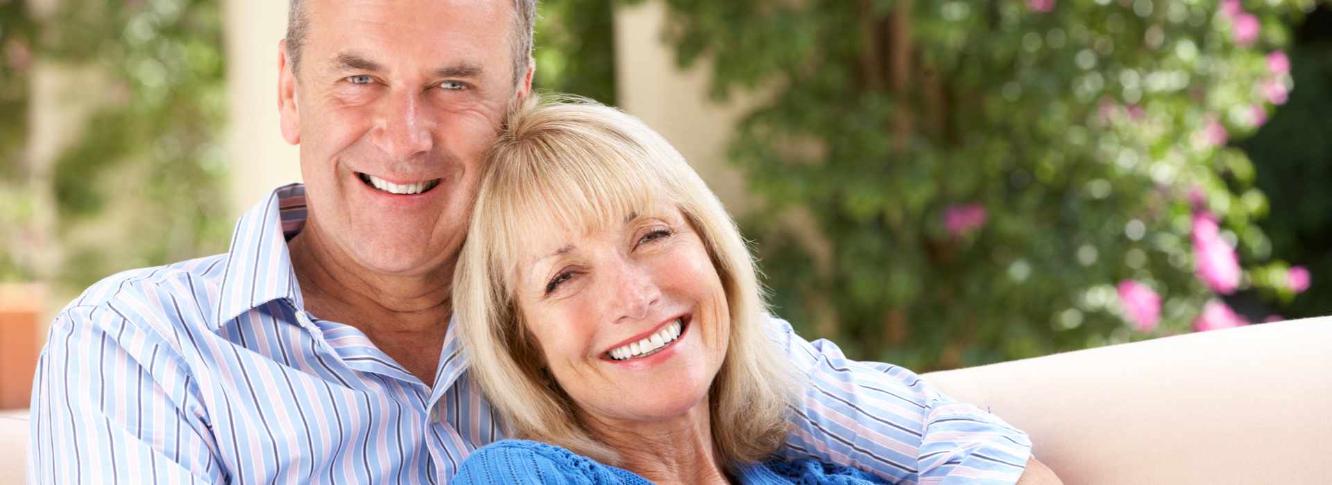A couple is smiling after dental implants.