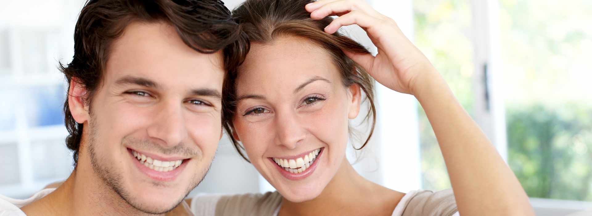 A beautiful couple is smiling after same-day crowns.